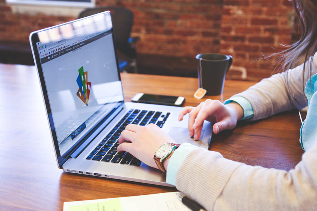 Designer works on custom pin design on her laptop computer